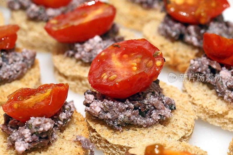 canapé with black olives and tomato confit